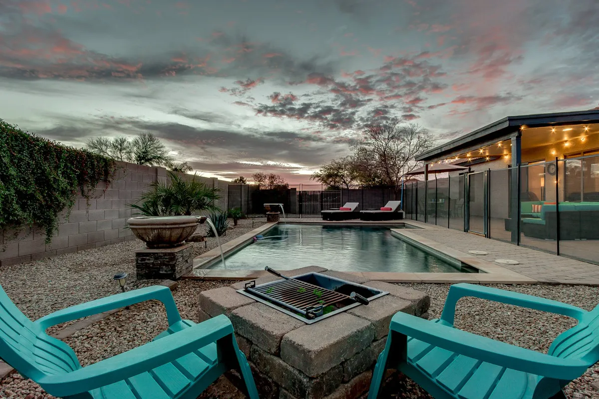 A tranquil backyard scene featuring a sparkling pool, lounge chairs, a fire pit, and an open sky. The setting is perfect for relaxation after running errands or exploring local attractions. The image evokes feelings of peace, comfort, and the option to unwind by the pool—the very essence of the section's promise to long-term guests.